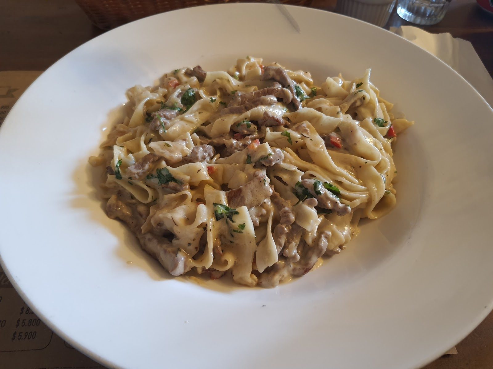 Plato de fettuccine con carne en salsa, servido en El Tumbaito